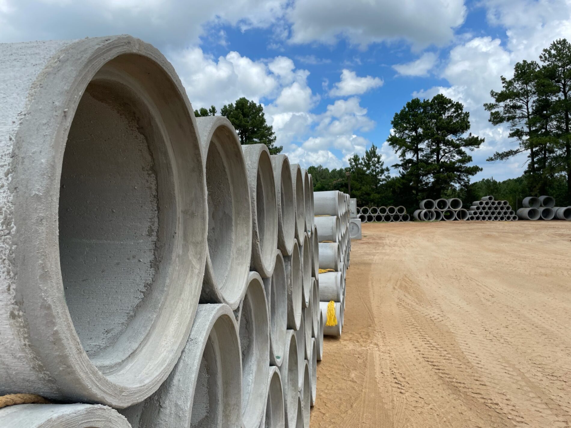 stack of circular concrete pipes on a dirt lot