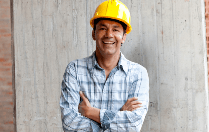 Contractor smiling with a yellow hard hat on